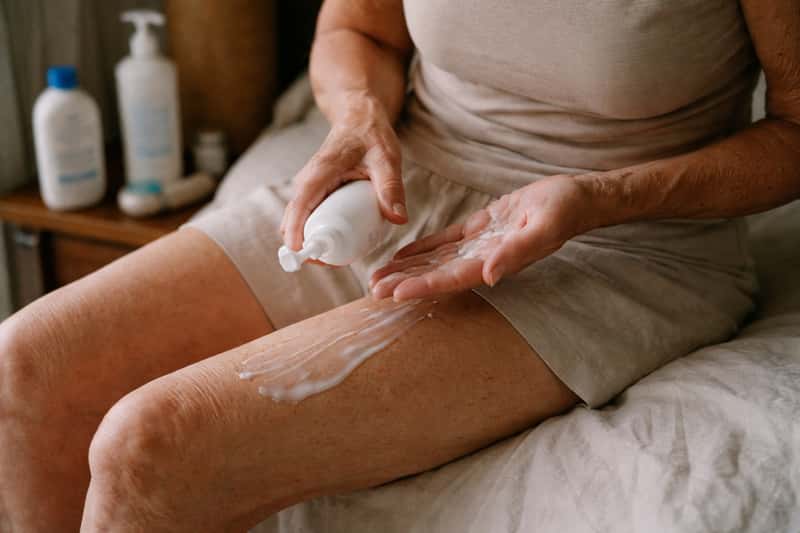 Thin lotion pooling on creased, papery skin texture, showing Thin lotion pooling on creased, papery skin texture, showing poor absorption and visible gaps in coverage